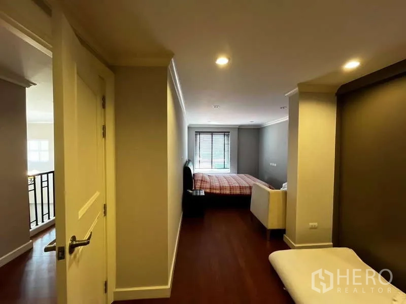 独立式住宅 出租在Prawet, Bangkok - 二层走廊通往卧室，木地板与采光窗。