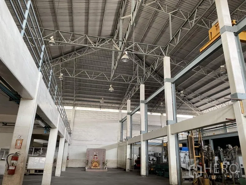 Factory for sale in Khlong Luang, Pathum Thani - High-ceiling manufacturing area with steel trusses and pendant lighting.