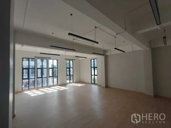 带办公室的家 出租在Bang Kapi, Bangkok - 大开间办公空间，层高高，线性吊灯与落地窗。