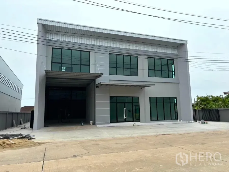 Factory for rent or sale in Bang Bo, Samut Prakan - Modern two-storey factory exterior with glass-front offices and wide driveway in Bang Bo, Samut Prakan.