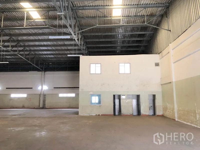 Factory for rent in Nonthaburi - Factory interior showing a central two-storey office core and restrooms.