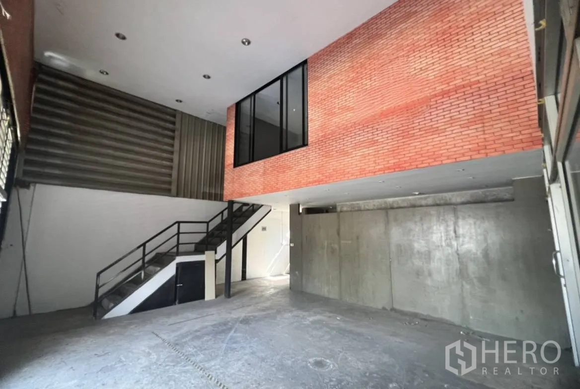 货栈 出租在Suan Luang, Bangkok - 入口大厅层高挑高，砖饰面夹层办公室与金属楼梯。