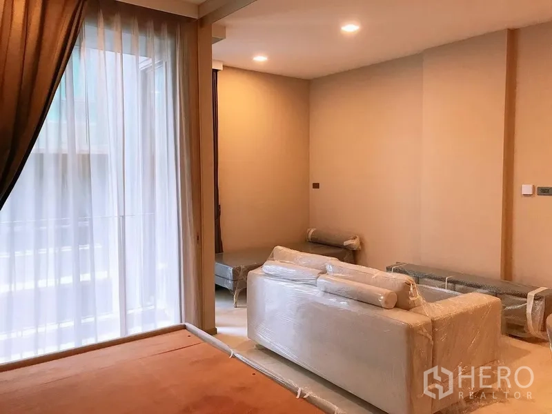 คอนโด ให้เช่าในWatthana, Bangkok - ห้องนอนกั้นด้วยประตูสไลด์เปิดสู่ห้องนั่งเล่นและระเบียงพร้อมม่านโปร่ง