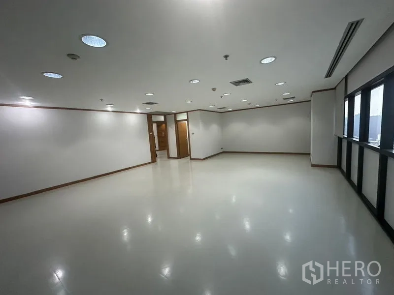 办公空间 出租在Phaya Thai, Bangkok - 大开间办公层，嵌入式灯具、空调出风口与整排窗户。