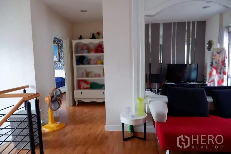 Detached House for sale in Saphan Sung, Bangkok - Second-floor hallway with staircase, shelving and wood floors.