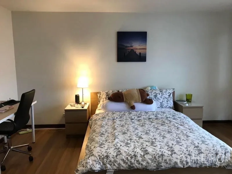 Townhouse for sale in Suan Luang, Bangkok - Cozy bedroom with study desk, bedside tables and warm lighting.