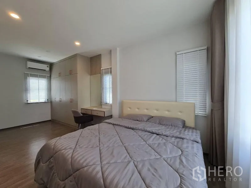 Detached House for rent in Samut Prakan - Spacious master bedroom with built-in wardrobe, vanity and wood floors.