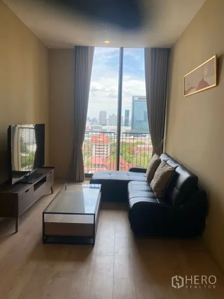 Condominium for rent in Watthana, Bangkok - Living area with full-height window showcasing Bangkok city skyline views.