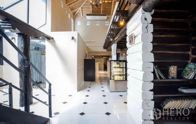 Retail Space for rent in Khlong Toei, Bangkok - Spacious hall with mezzanine, chandeliers and display fridge under a vaulted ceiling.
