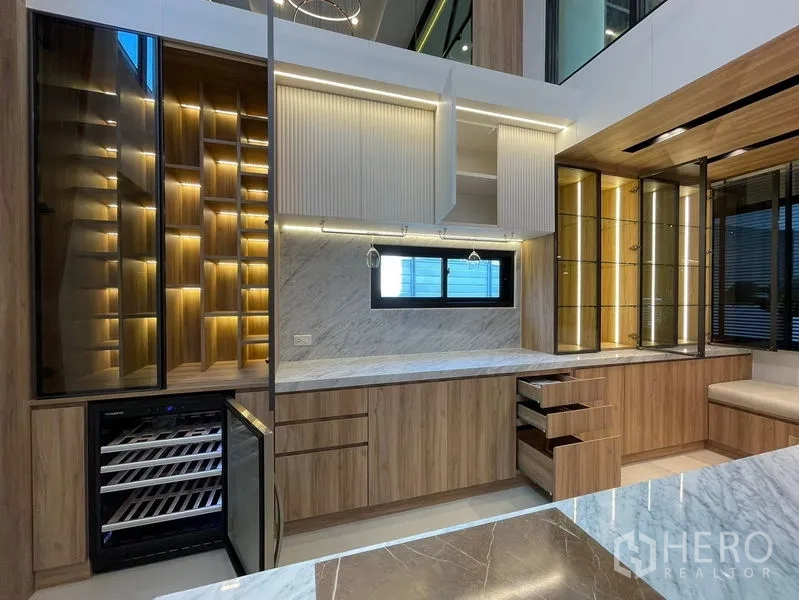 联排别墅 出售 - 展示厨房配大理石台面、酒柜及带灯展示柜。