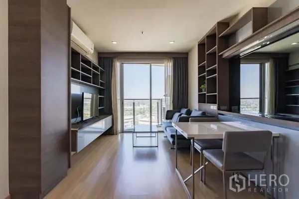 Condominium for rent - Bright living room with built-in shelving, dining set and a balcony overlooking the Bangkok city skyline in a Watthana condo.