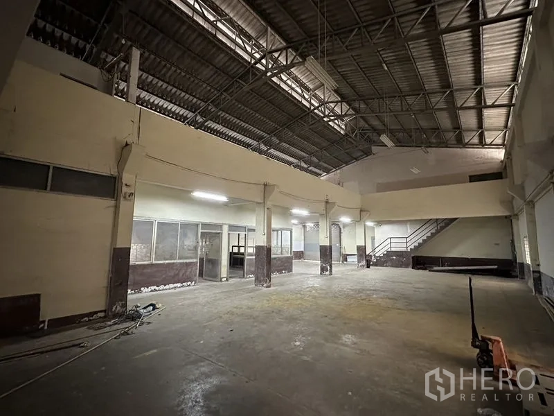Factory for rent in Bang Bua Thong, Nonthaburi - Warehouse floor with mezzanine platform and stair access.