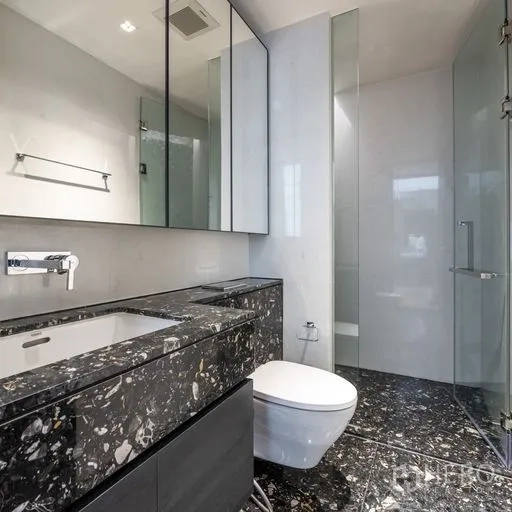 Condominium for rent in Khlong Toei, Bangkok - Modern bathroom with black marble vanity, mirrored cabinets, glass shower and white walls.