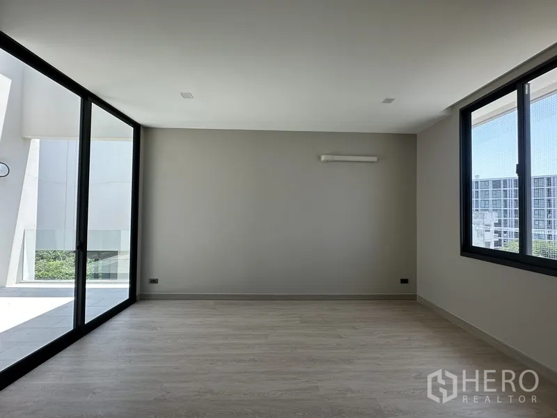家庭办公室 for rent or sale in Suan Luang, Bangkok - 楼上房间木地板，推拉门连接阳台。