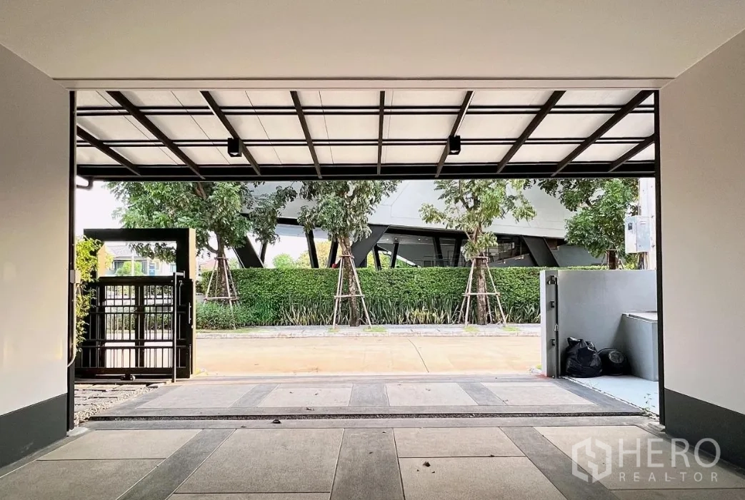 Detached House for rent or sale in Lam Luk Ka, Pathum Thani - Covered carport interior looking out to the street and clubhouse.
