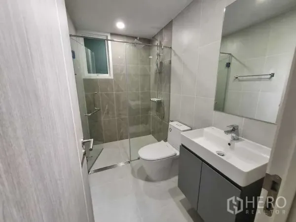 Condominium for rent - Contemporary bathroom featuring a glass-enclosed shower, vanity and toilet.