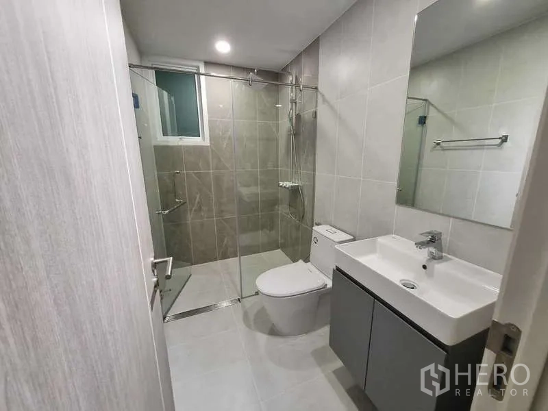 Condominium for rent - Contemporary bathroom featuring a glass-enclosed shower, vanity and toilet.