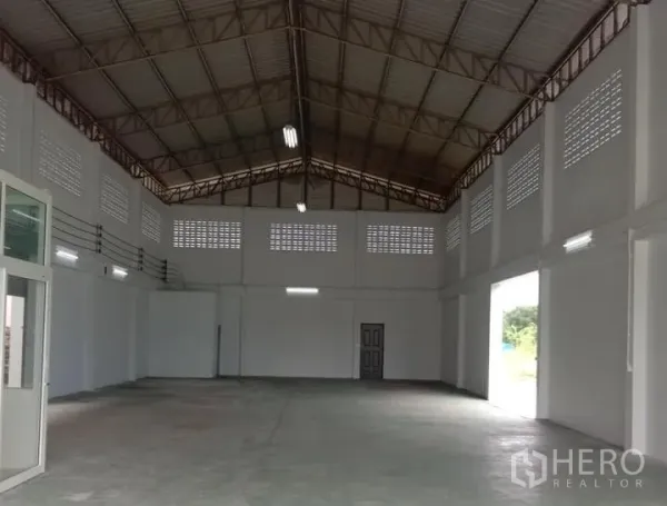 Factory for rent in Lat Lum Kaeo, Pathum Thani - High-ceiling factory hall with steel truss roof, ventilation blocks, and large roller door openings.