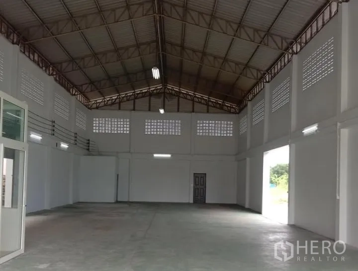 Factory for rent in Lat Lum Kaeo, Pathum Thani - High-ceiling factory hall with steel truss roof, ventilation blocks, and large roller door openings.
