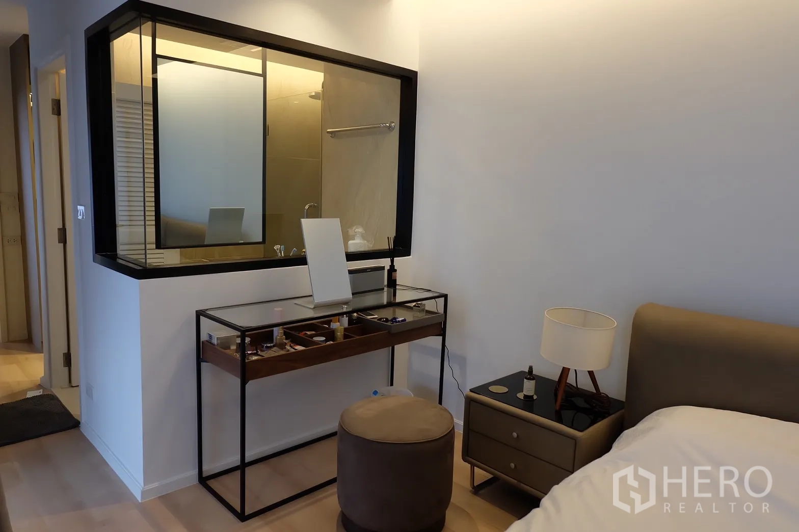Condominium for rent in Bang Rak, Bangkok - Bedroom corner with vanity desk and framed glass to bathroom in a Bangkok condo.