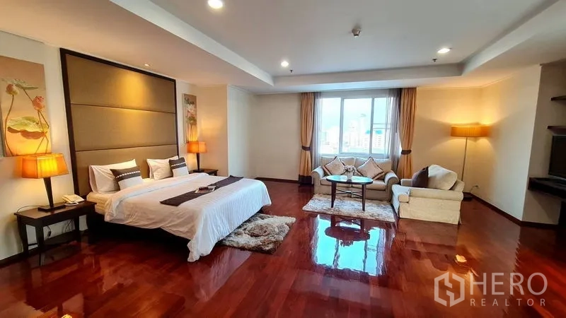 房间 出租在Watthana, Bangkok - 宽阔主卧，抛光木地板与会客区，大窗采光充足。