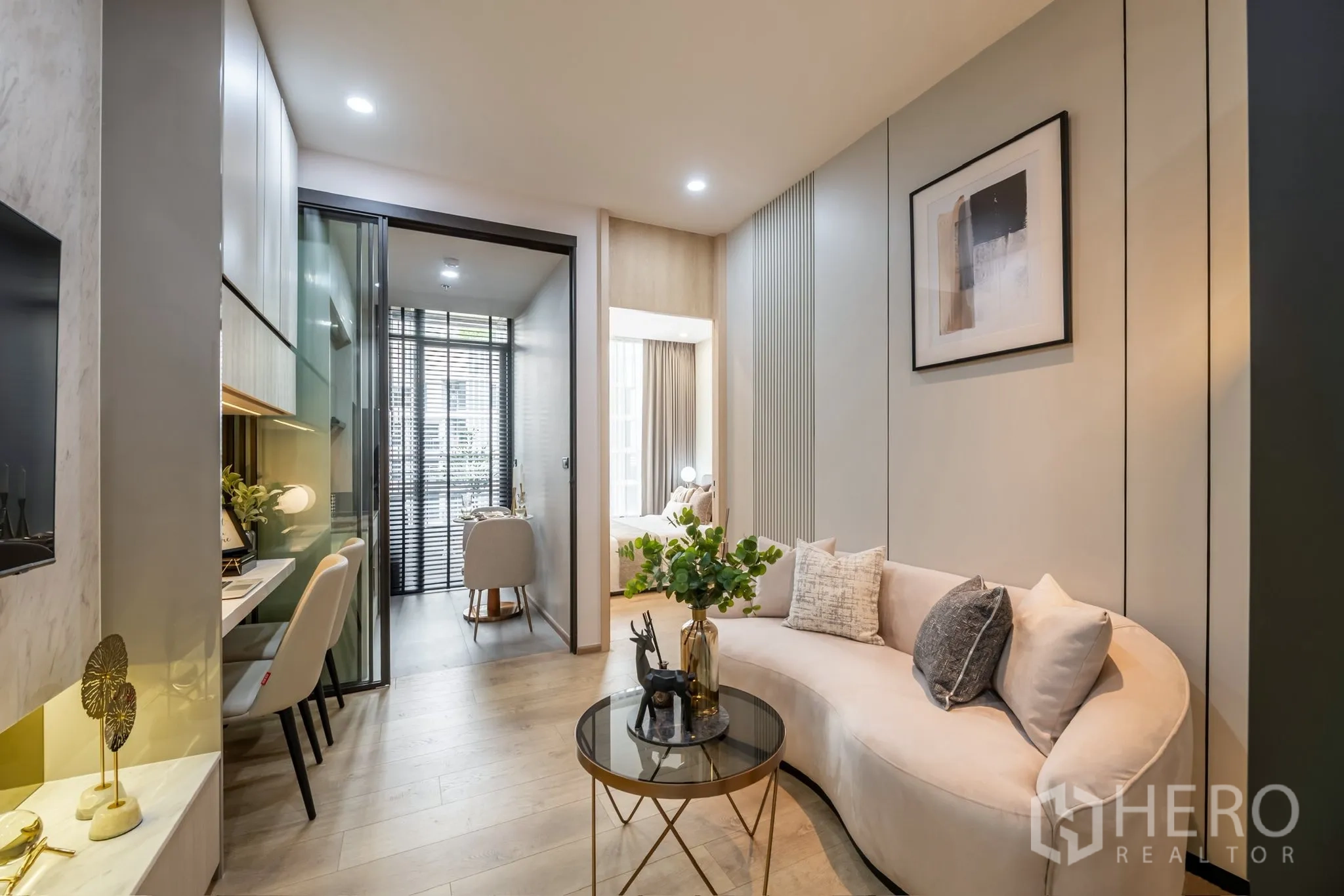 คอนโด for rent in Watthana, Bangkok - ห้องนั่งเล่นสว่างพร้อมโซฟาทรงโค้ง โต๊ะกลางกระจก มุมทำงานบิวท์อิน ประตูกระจกบานเลื่อน และมุมทานอาหารริมหน้าต่างสูง.
