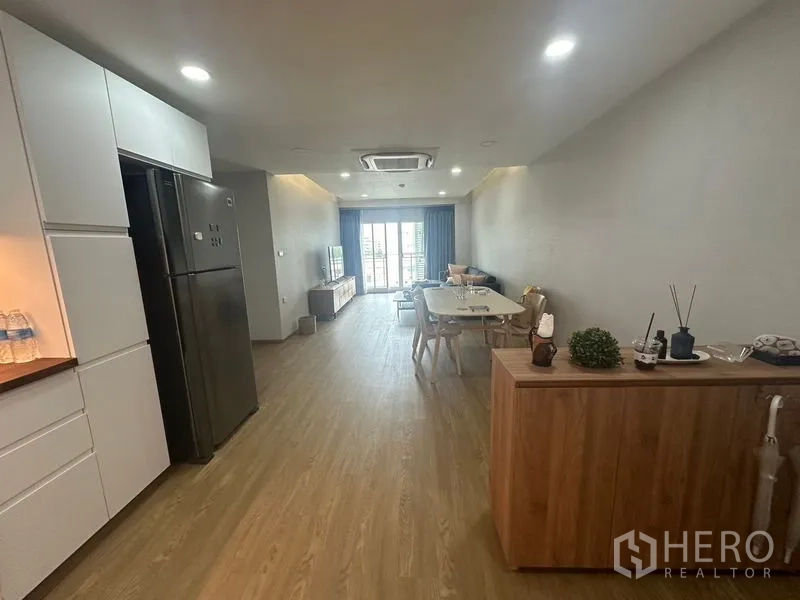 คอนโด ให้เช่า - พื้นที่นั่งเล่น‑รับประทานอาหารแบบเปิดเชื่อมระเบียง ครัวอยู่ด้านซ้าย