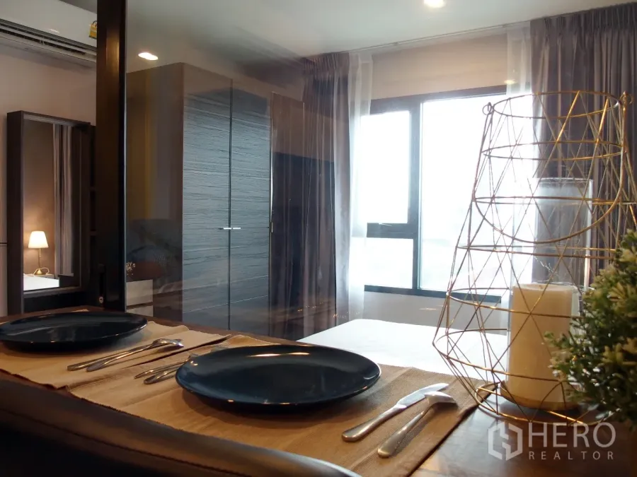 คอนโด ให้เช่าในHuai Khwang, Bangkok - มุมทานอาหารข้างหน้าต่างและผนังกระจก มองเห็นห้องนอนตู้เสื้อผ้าและผ้าม่านโปร่งในคอนโดกรุงเทพฯ