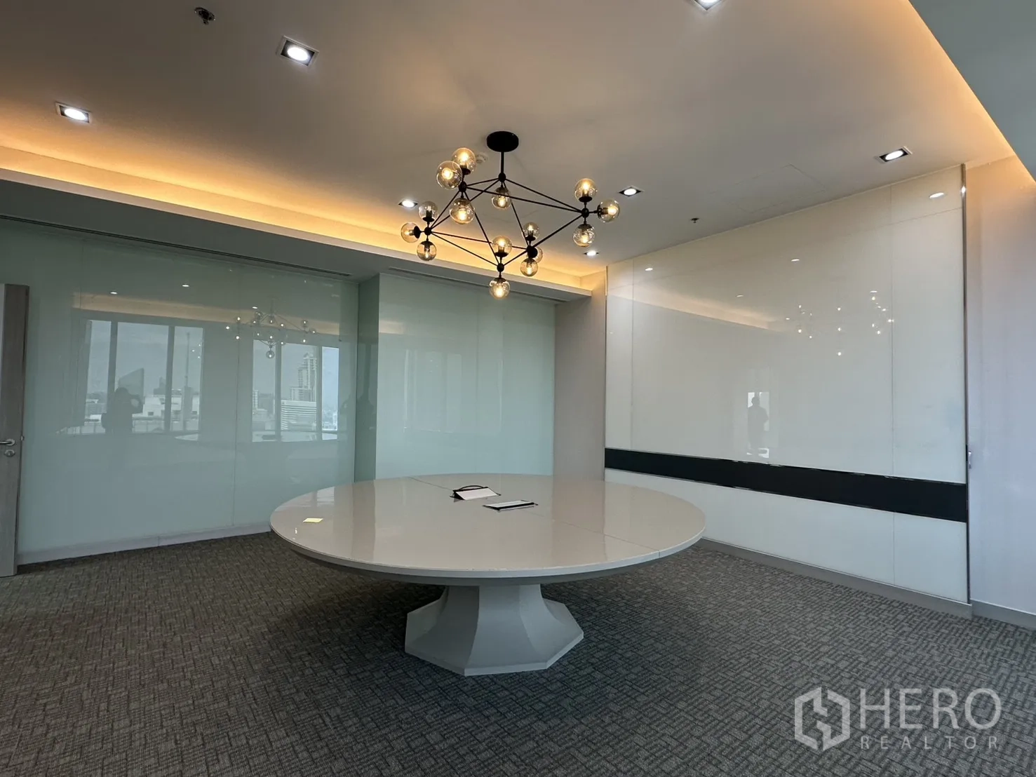 办公室 for rent in Khlong Toei, Bangkok - 现代会议室，配大型圆桌、吊灯与玻璃墙面。