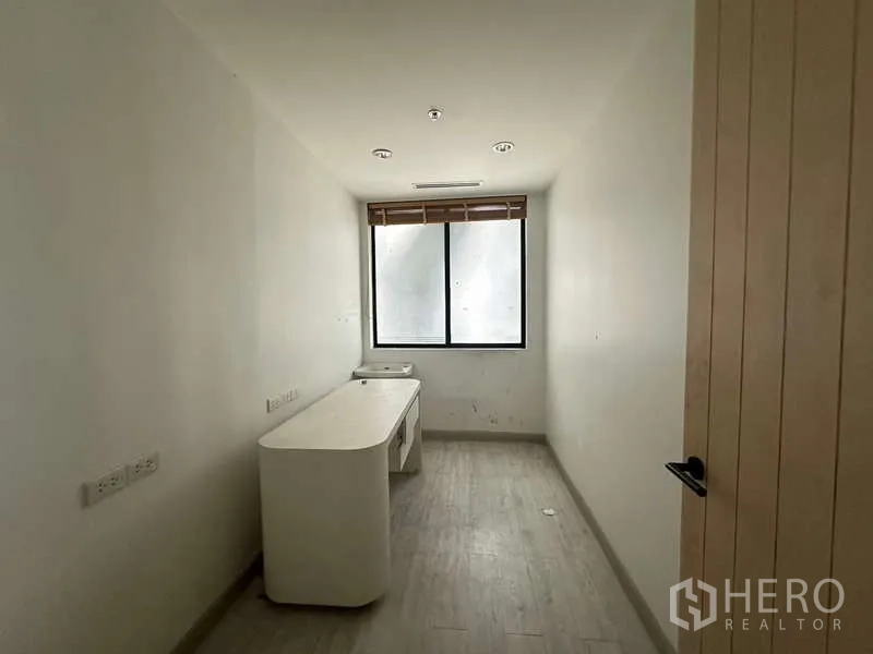 Retail Space for rent in Pathum Wan, Bangkok - Narrow consultation room with desk and window letting in light.