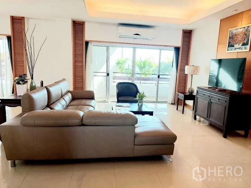 Apartment for rent - Sunny living room with L-shaped sofa, TV console and balcony sliding doors.