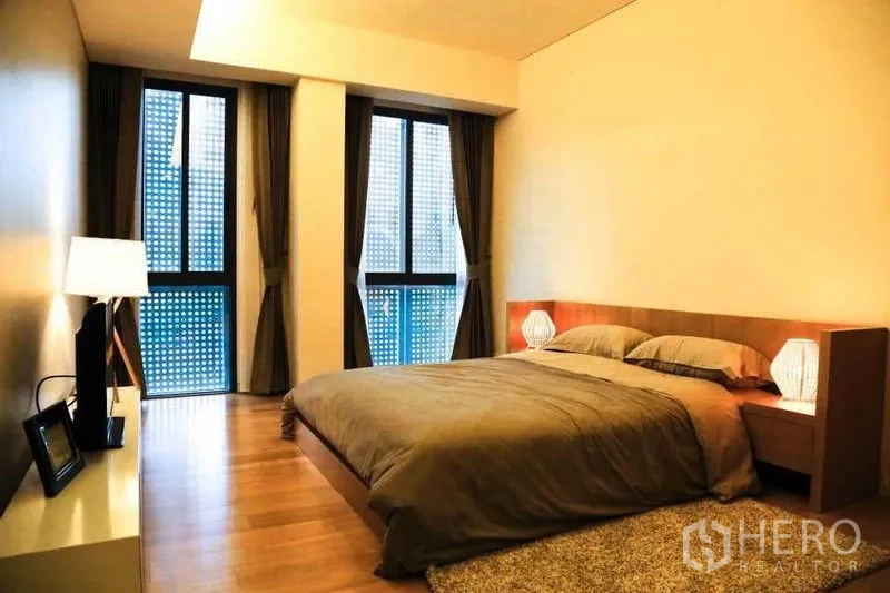 公寓 出租在Watthana, Bangkok - 主卧配大床、床头灯，落地窗与木地板。
