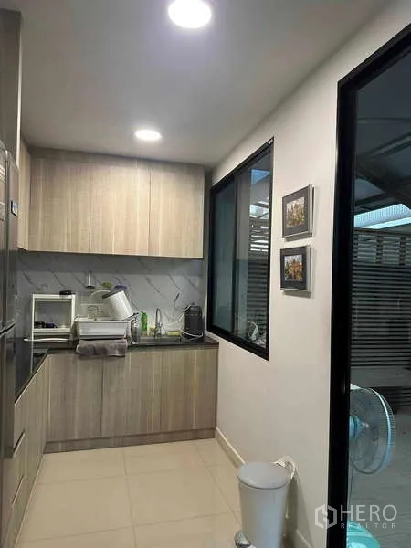 带办公室的家 出租在Bueng Kum, Bangkok - 紧凑茶水间，浅木柜、洗涤槽与窗户，整洁实用。