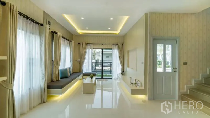 独立式住宅 出租或出售在Lat Krabang, Bangkok - 开放式客厅带氛围灯、亮面地坪与通往露台的推拉门。