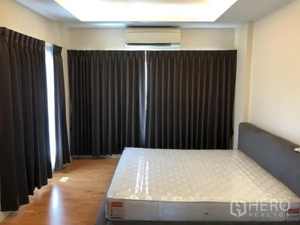 Detached House for rent in Saphan Sung, Bangkok - Primary bedroom with large windows, blackout curtains, air conditioning and a queen bed.