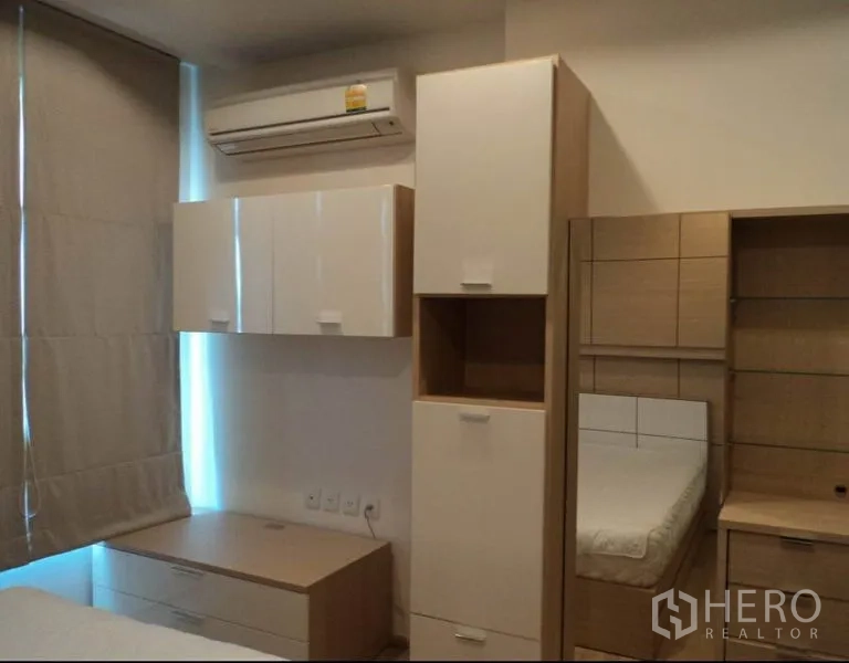 Condominium for rent in Khlong Toei, Bangkok - Bedroom with built-in storage, air conditioner, window blinds, and a bed.