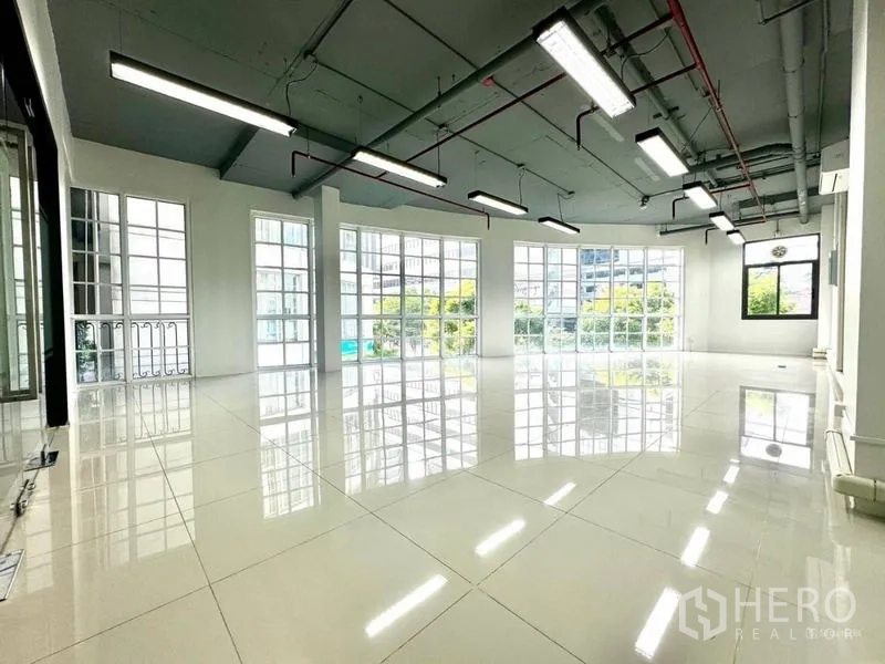 Office Space for rent in Khlong Toei, Bangkok - Spacious open-plan office with large grid windows and glossy tile floors