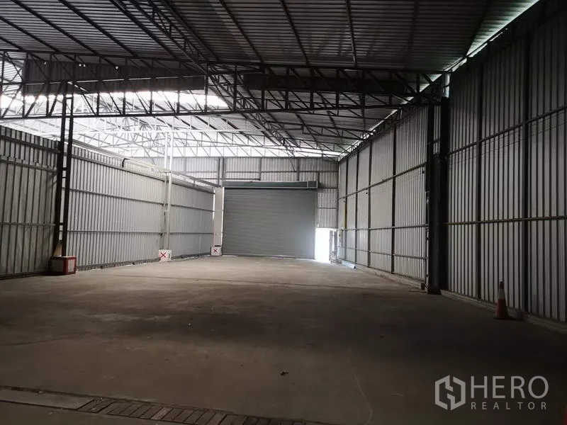 Warehouse for rent in Pak Kret, Nonthaburi - Loading bay area with an interior roller shutter door inside a metal‑clad warehouse.