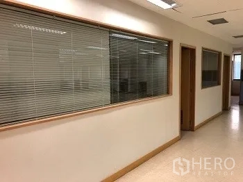 Office Space for rent or sale in Bang Rak, Bangkok - Bright office corridor with glass windows and blinds in a Pathum Wan building.