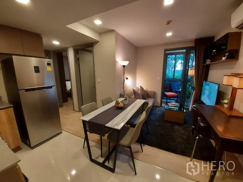 公寓 出租或出售在Watthana, Bangkok - 开放式客餐厅，配沙发、大理石餐桌与阳台景观，近Ekkamai的公寓。