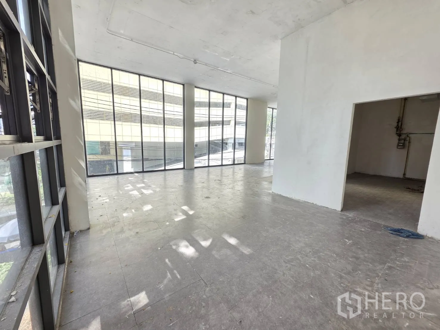 Retail Space for rent in Watthana, Bangkok - Corner-style area with wraparound glazing and a separate back room visible.
