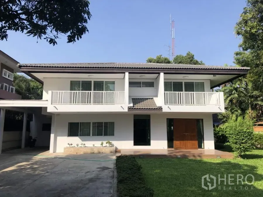 บ้าน ให้เช่าในSuan Luang, Bangkok - บ้านเดี่ยวสองชั้นสีขาวพร้อมระเบียงคู่ ทางรถเข้ากว้างและสนามหญ้าหน้าบ้าน