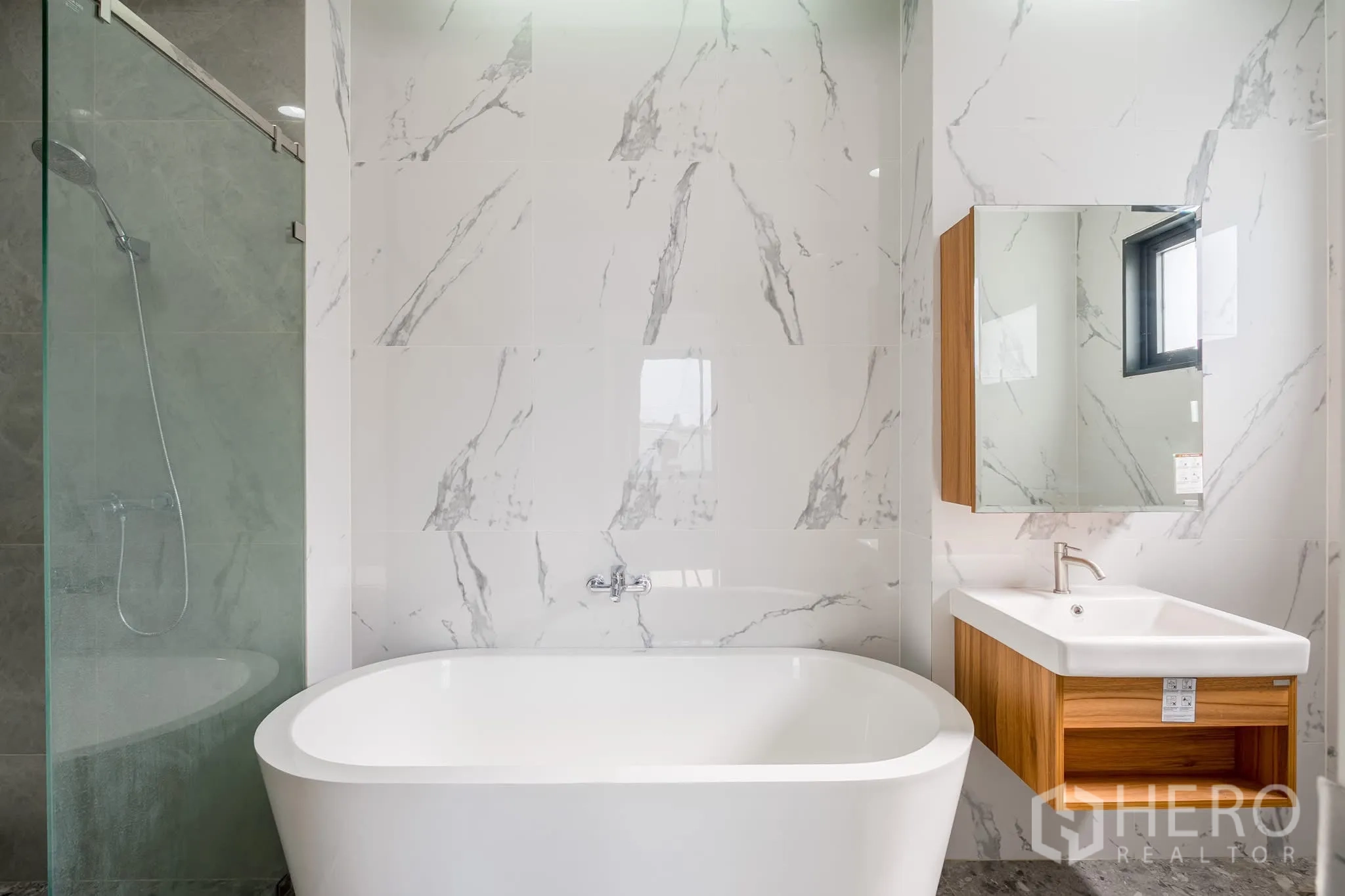 Home Office for rent in Khlong Toei, Bangkok - Modern bathroom with freestanding bathtub, marble walls, glass shower and wood vanity.