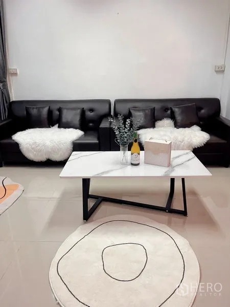 Townhouse for rent in Huai Khwang, Bangkok - Close-up of living area featuring leather sofas and a marble coffee table.