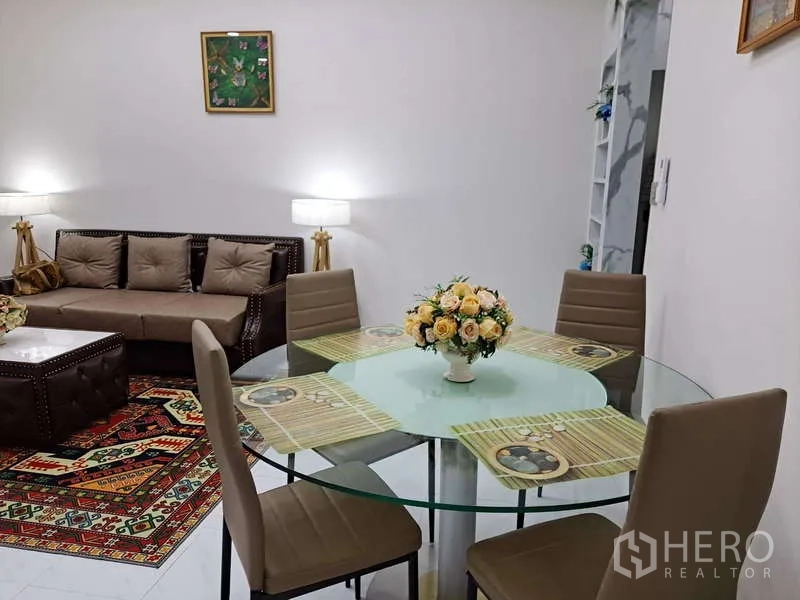 公寓 出租在Khlong Toei, Bangkok - 四人圆形玻璃餐桌配花艺中心摆件，后方为客厅。