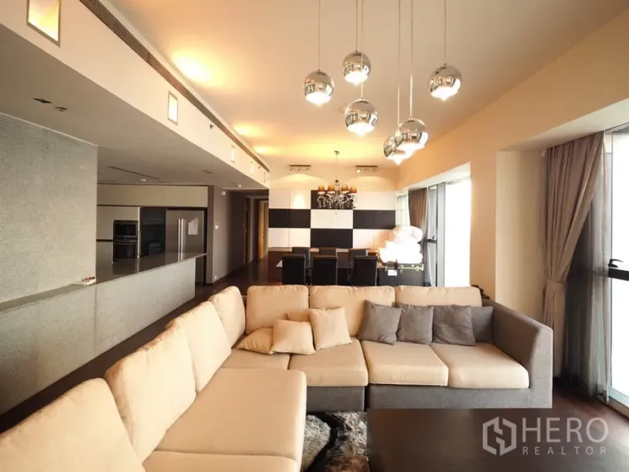 คอนโด ให้เช่าในSathon, Bangkok - ห้องนั่งเล่นและรับประทานอาหารแบบโอเพ่นแพลน โซฟาตัวยาว โคมไฟห้อย และหน้าต่างวิวเมือง