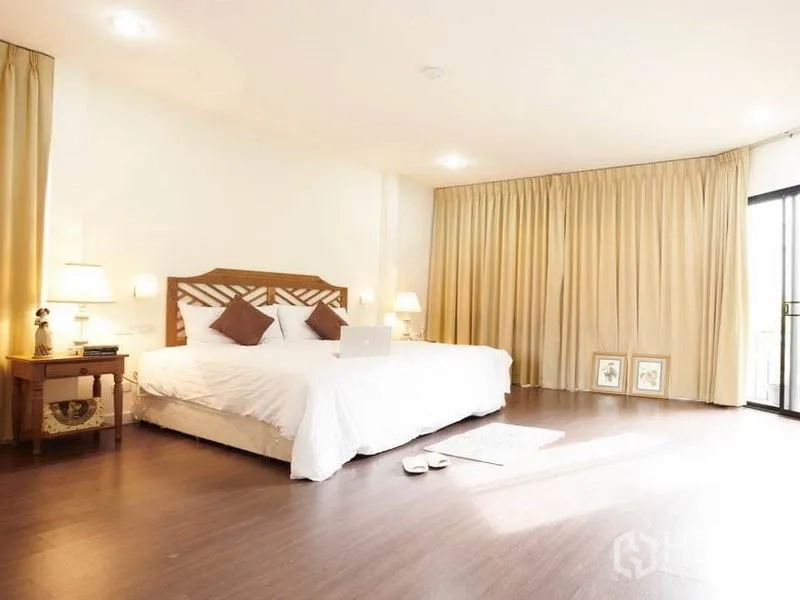 Detached House for rent in Khlong Toei, Bangkok - Spacious master bedroom with wood flooring and soft lighting