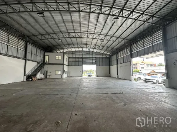 โรงงาน ให้เช่าในPathum Thani - ฮอลล์โรงงานแบบเปิดโล่ง มองออกไปยังประตูขนถ่ายขนาดใหญ่และพื้นที่จอดรถ