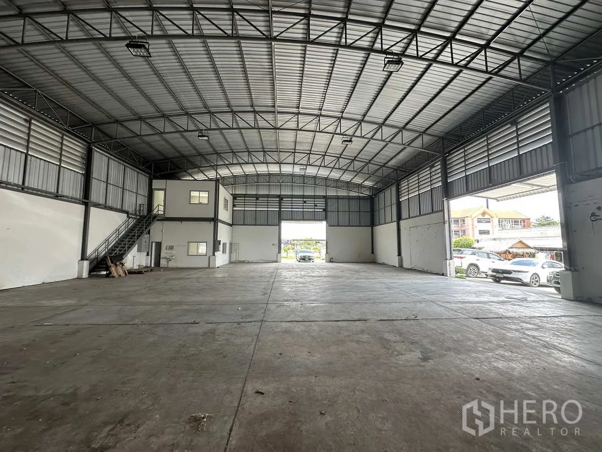 โรงงาน ให้เช่าในPathum Thani - ฮอลล์โรงงานแบบเปิดโล่ง มองออกไปยังประตูขนถ่ายขนาดใหญ่และพื้นที่จอดรถ