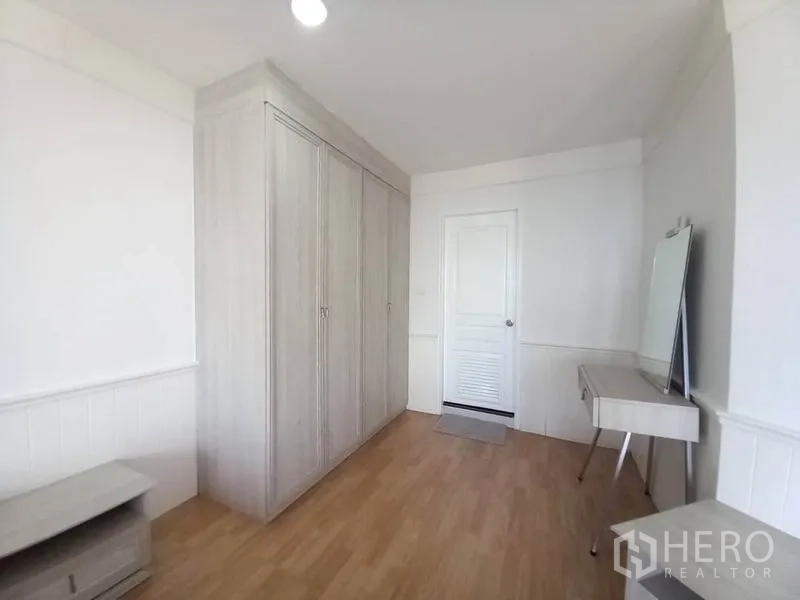 Condominium for rent in Khlong Toei, Bangkok - Hallway corner with full-height built-in wardrobes and a vanity desk.